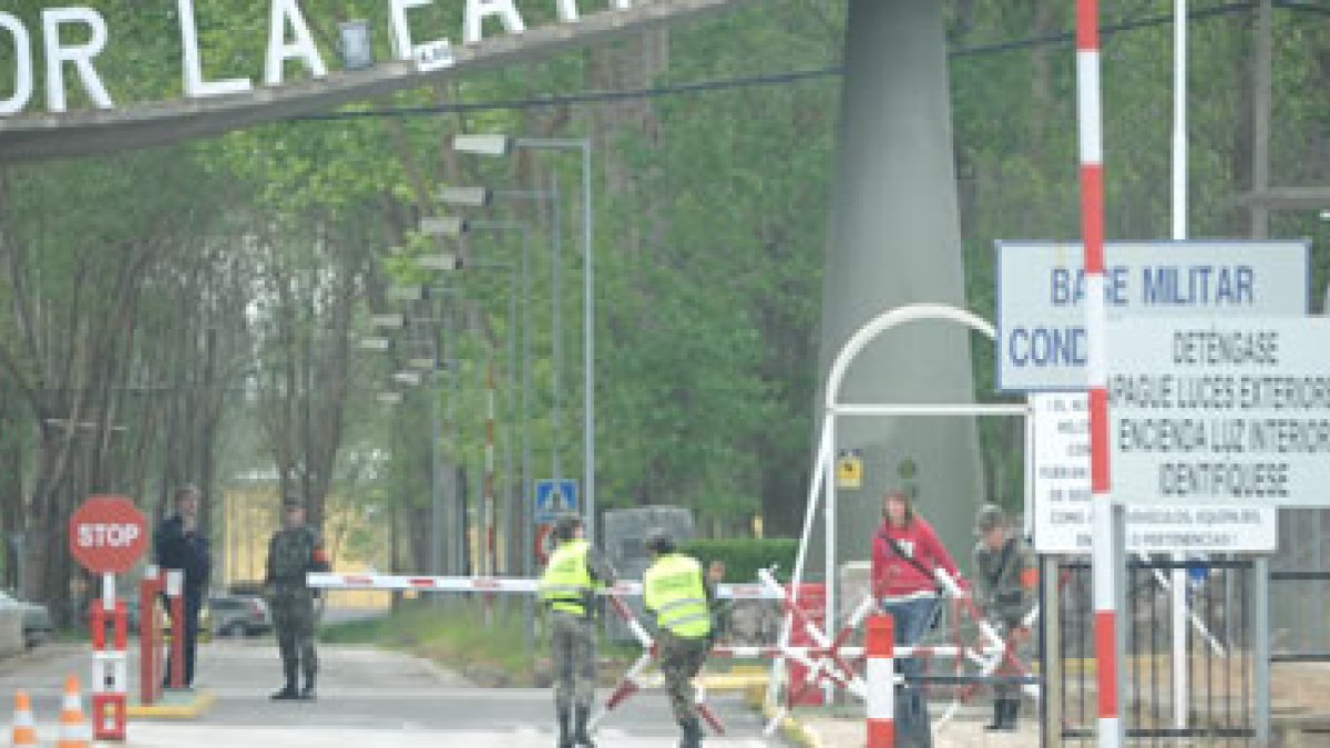 Los militares colocan un sistema de seguridad de entrada a la base a la vez que sale una soldado de