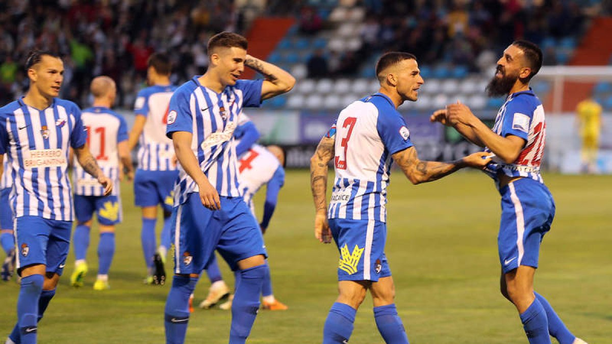 Los jugadores de la SD Ponferradina celebran con Carlos Bravo los goles del futbolista berciano en el partido jugado en El Toralín. ANA F. BARREDO