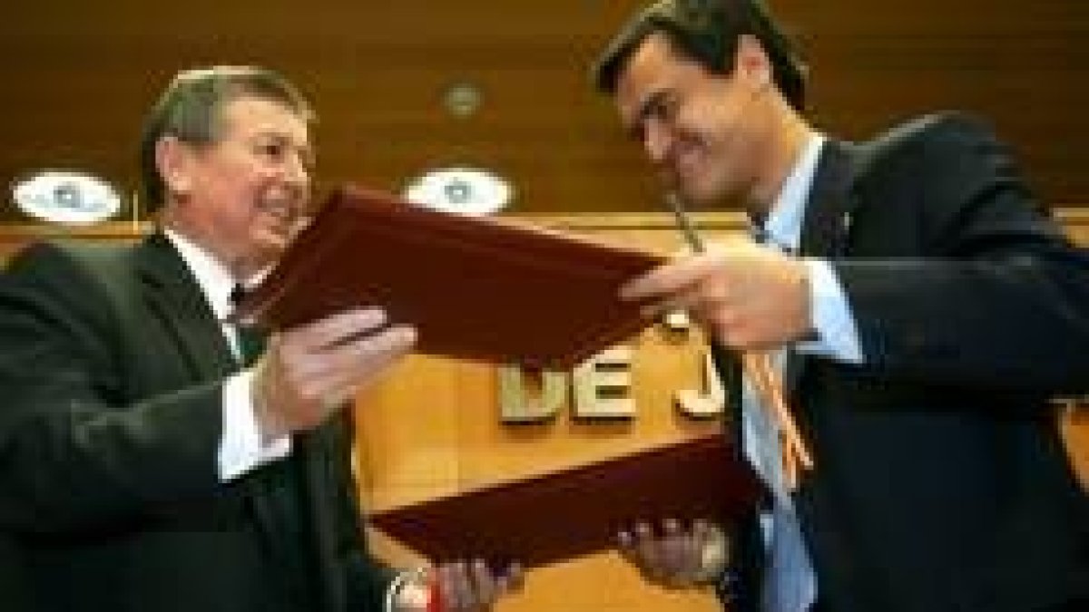 John Ashcroft y Juan Fernando López Aguilar se intercambian las firmas del acuerdo suscrito ayer