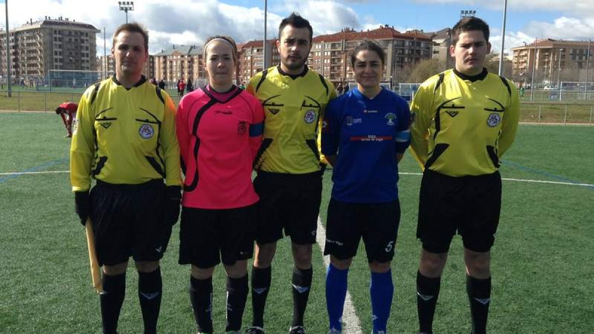 Las capitanas de ambos equipos posan con el trío arbitral.