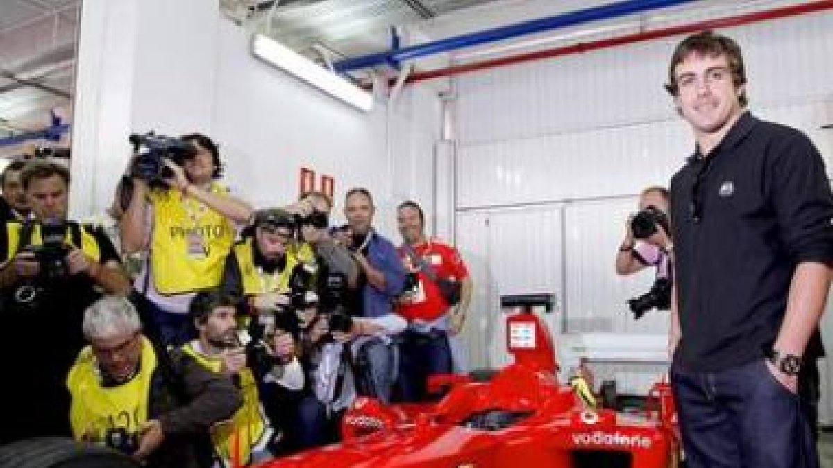 Fernando Alonso posa junto a un monoplaza de la escudería Ferrari.