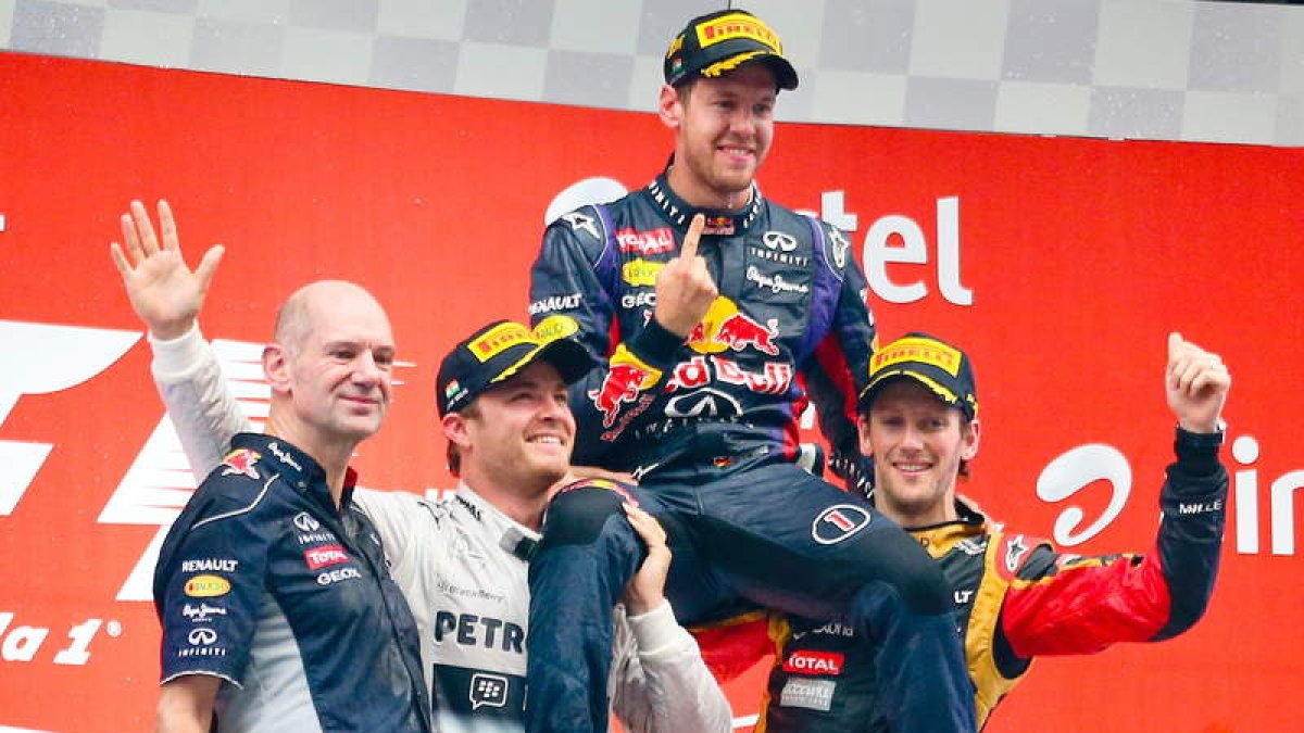 Rosberg y Grosjean levantan a Sebastian Vettel, campeón del mundo por cuarta vez.