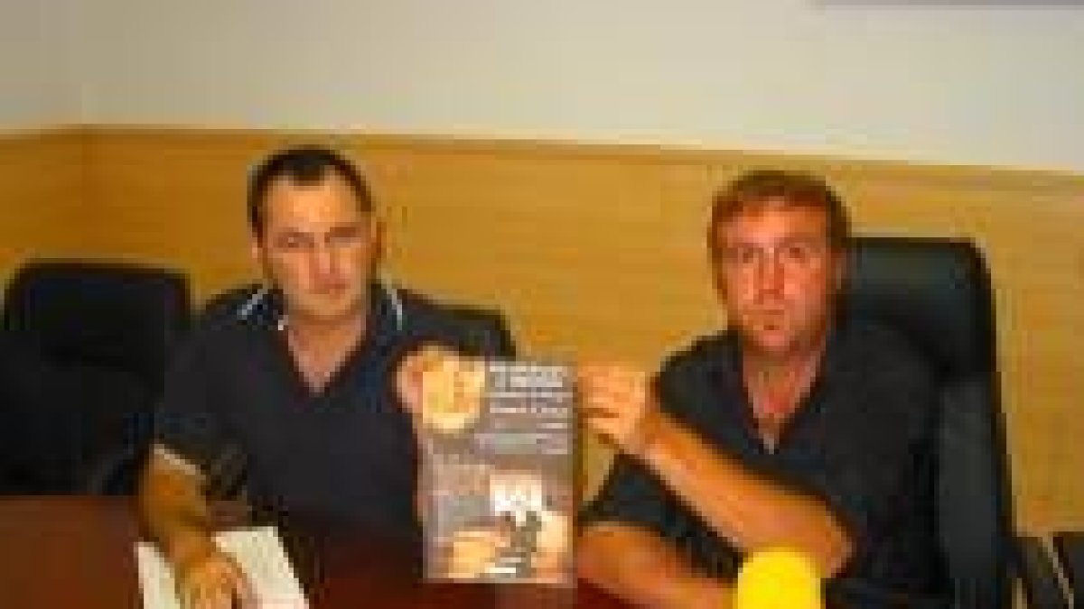 Javier Pinos y Jorge Fernández sujetan el cartel del homenaje a los repreasliados de 1936