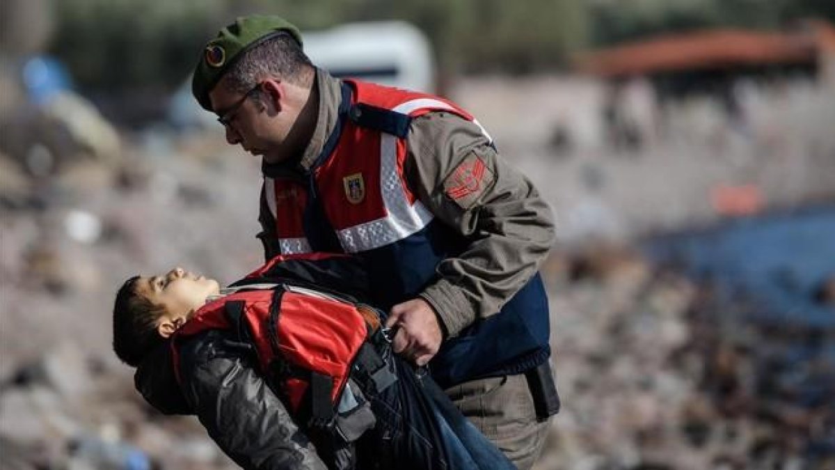 Un policía turco traslada el cuerpo sin vida de un niño tras otro naufragio en el Egeo.