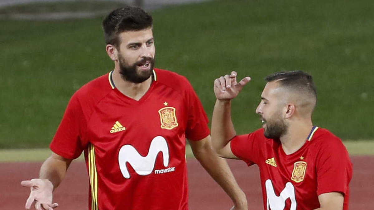 Piqué conversa con Jordi Alba durante el entrenamiento más complicado del central culé. CHEMA MOYA