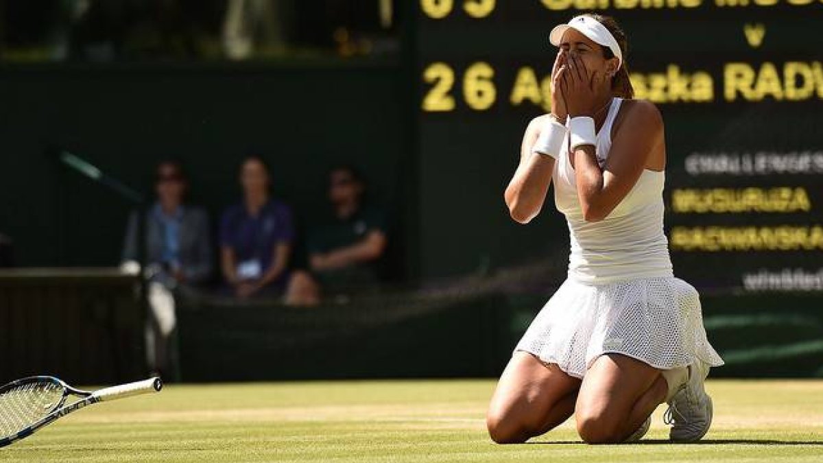 La tenista española Garbiñe Muguruza, arrodillada sobre el césped de Wimbledon, tras ganar a la polaca Agnieszka Radwanska y pasar a la final.