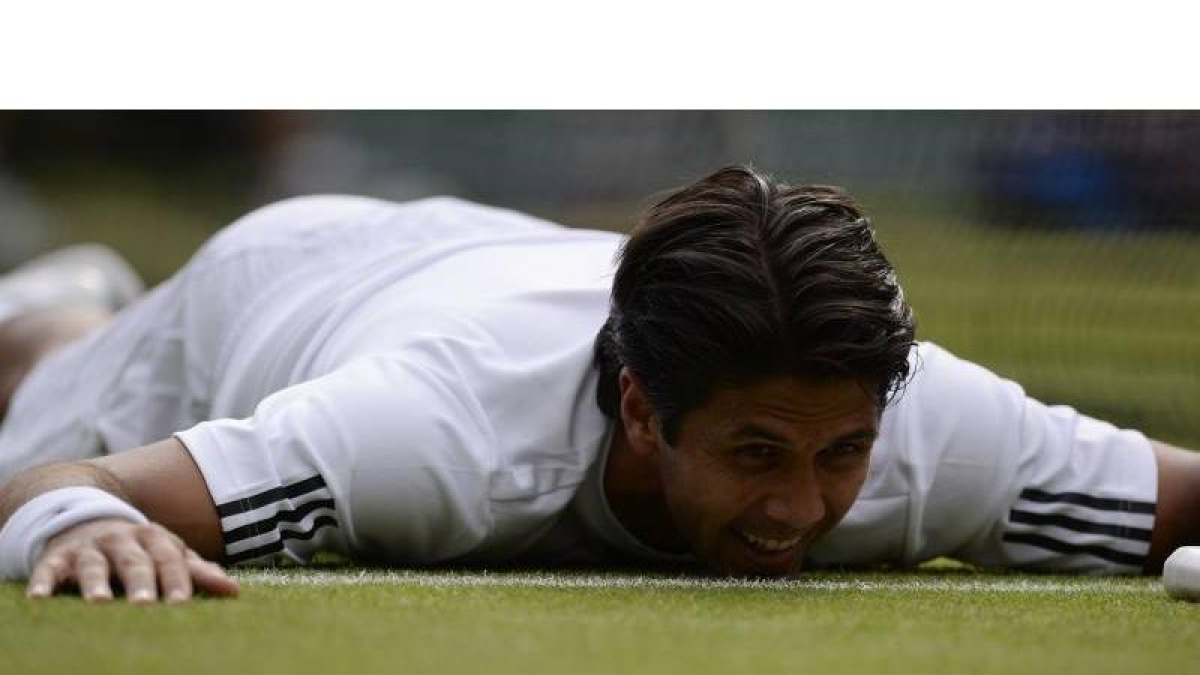 Fernando Verdasco tendido en el suelo de la pista central de Wimbledon tras intentar alcanzar la pelota, en un momento de su partido de cuartos de final ante Andy Murray.