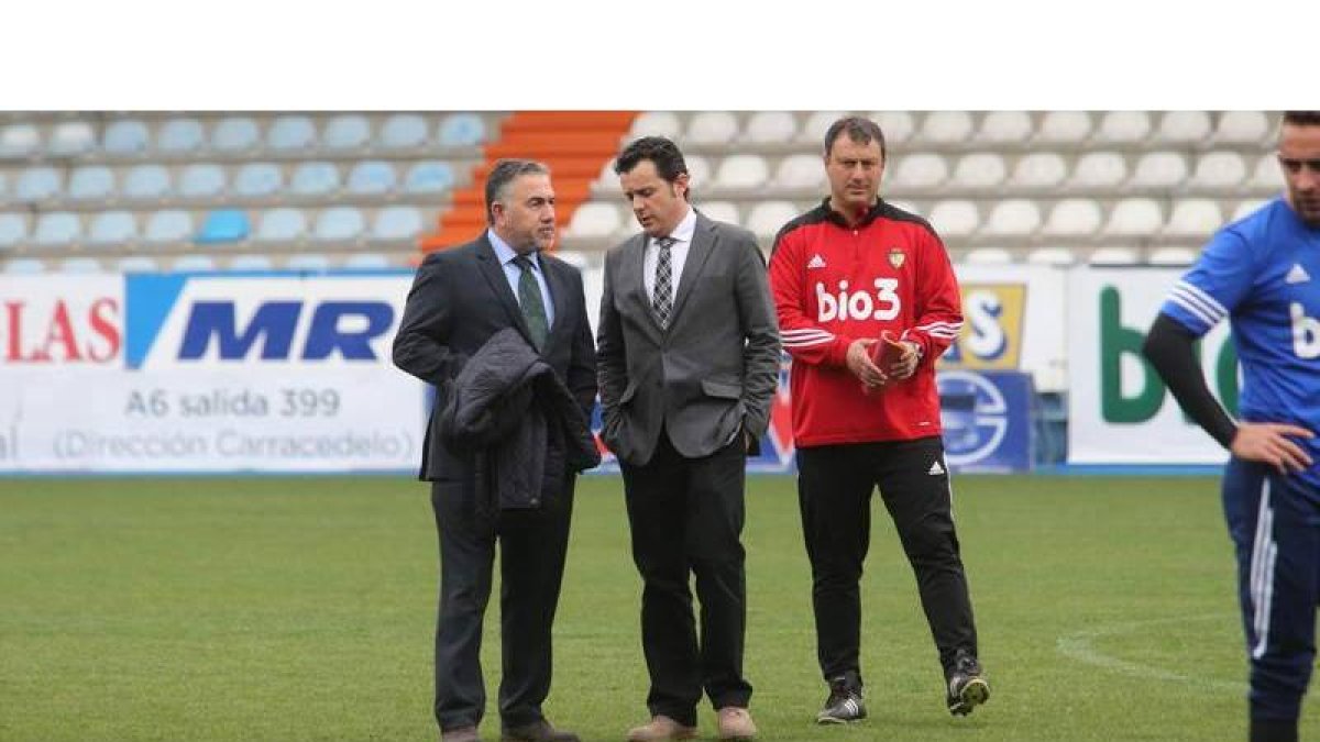 José Fernández Nieto y Eduardo Domínguez conversan sobre el césped de El Toralín en presencia del entrenador blanquiazul, José Manuel Díaz.