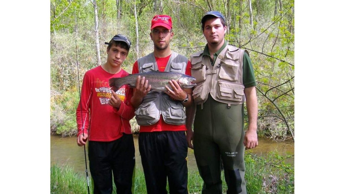 Álvaro, Luis Javier e Iván, con una trucha de tres kilos en el Porma.