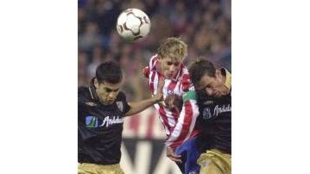 El atlético Fernando Torres golpea de cabeza entre Litos y Valcarce