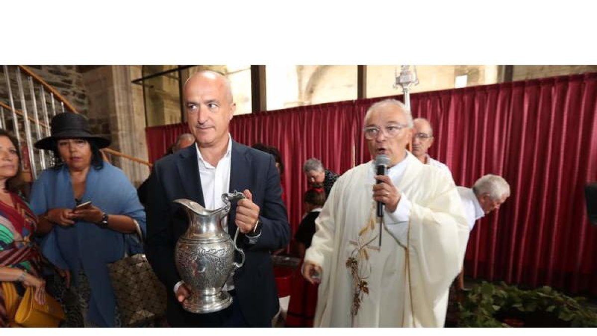 Julio Arias, ayer en la ofrenda junto al párroco, Jesús Álvarez, en el monasterio de Carracedo. L. DE LA MATA