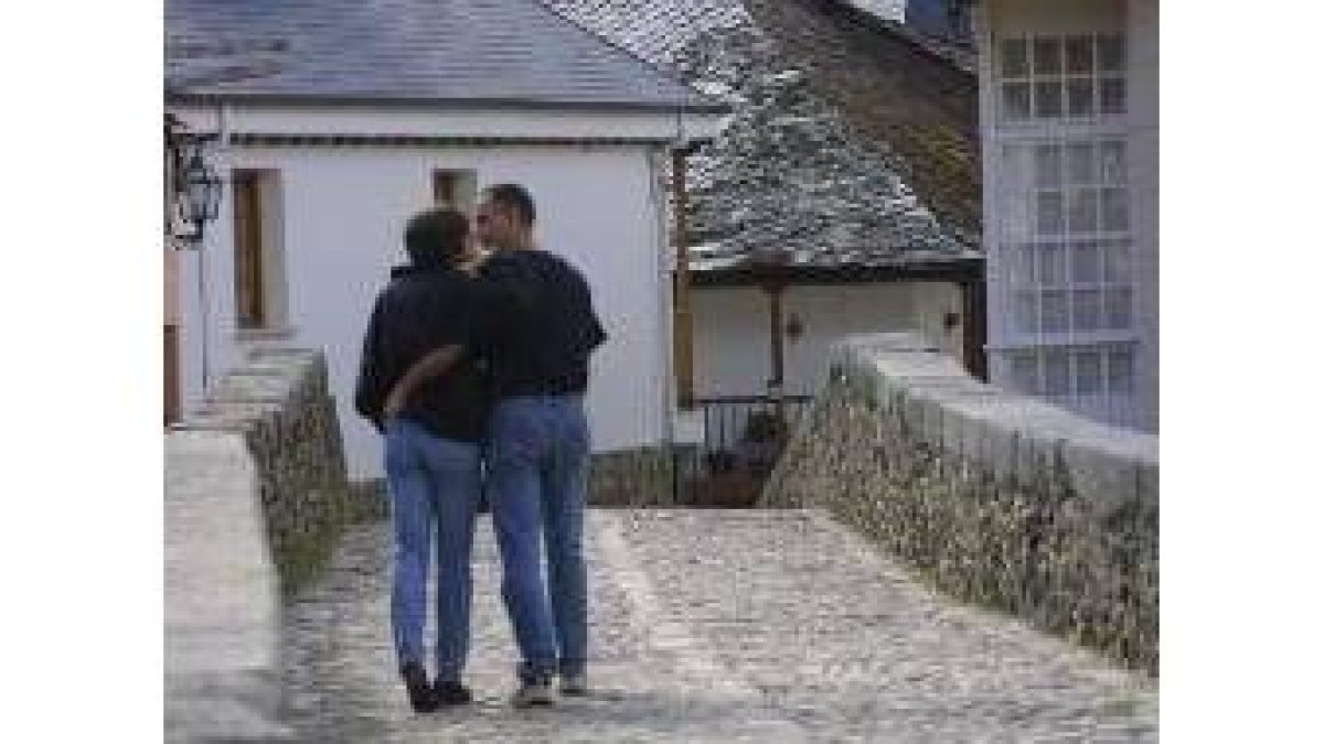 Una pareja de enamorados camina mientras disfruta del paisaje y de su amor