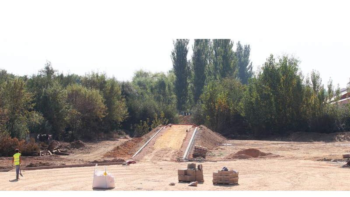 Un operario trabaja en la reconstrucción de la estructura del puente, que será peatonal.