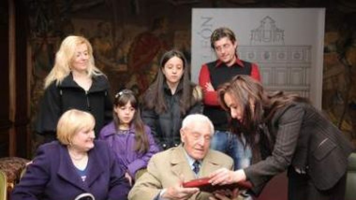 Laureano Moldes recibe un libro de regalo de la concejala Catalina Díaz, en presencia de su hija Mar