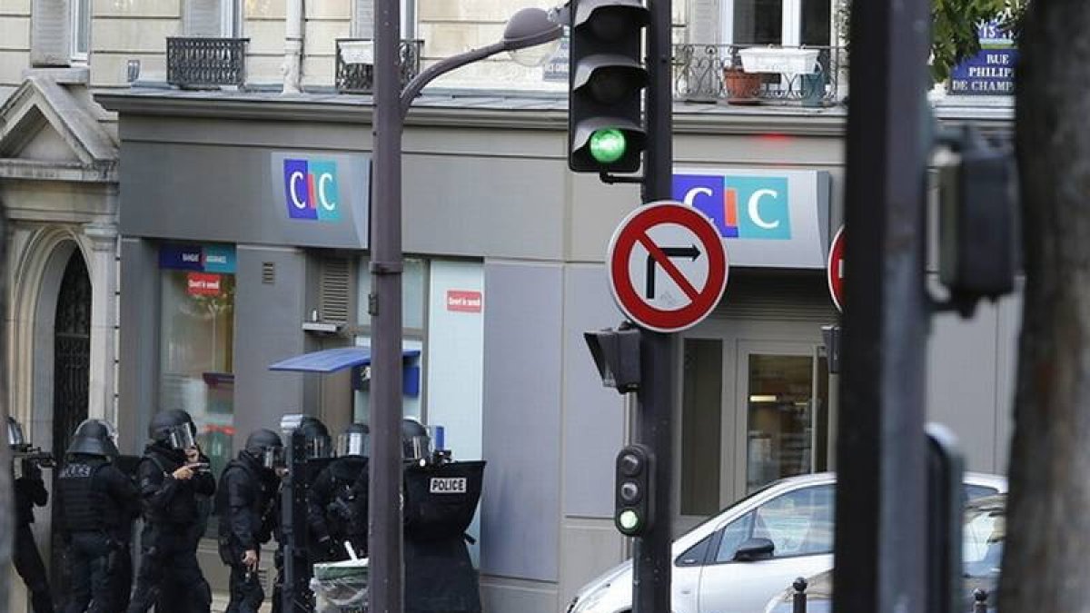 Agentes de la policía, a las puertas de la sucursal bancaria del CIC en el centro de París, este viernes.