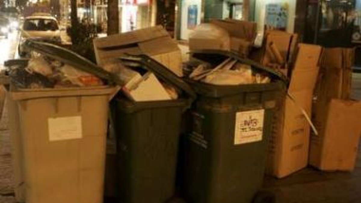 Contenedores a las puertas de los comercios tras una jornada de ventas en el centro de la capital