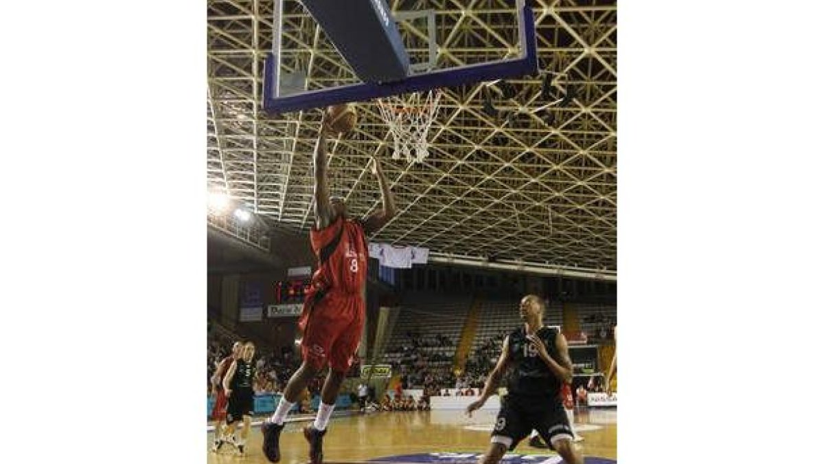 Seawright se dispone a ejecutar un mate en la canasta del Cáceres ante la mirada de Jeffrey Xavier.
