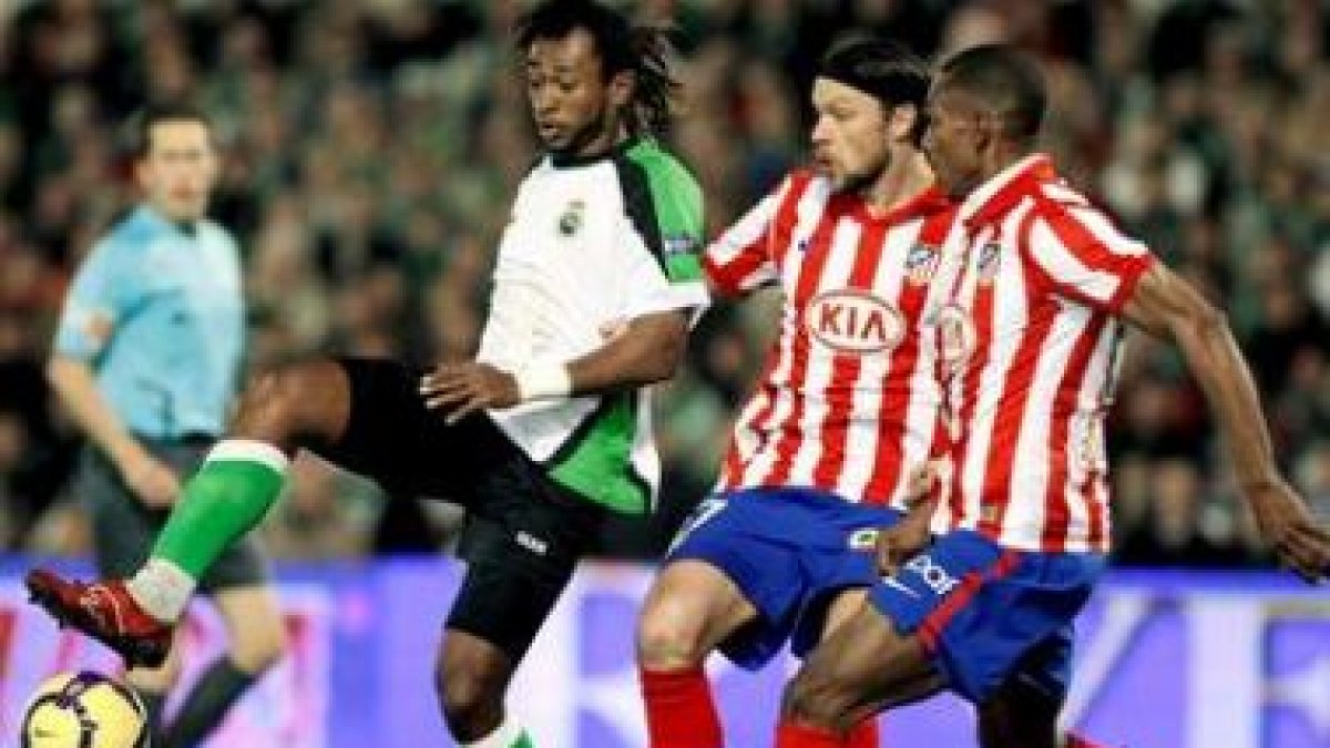 El delantero del Racing Tchité controla el balón ante los defensas del Atlético de Madrid.