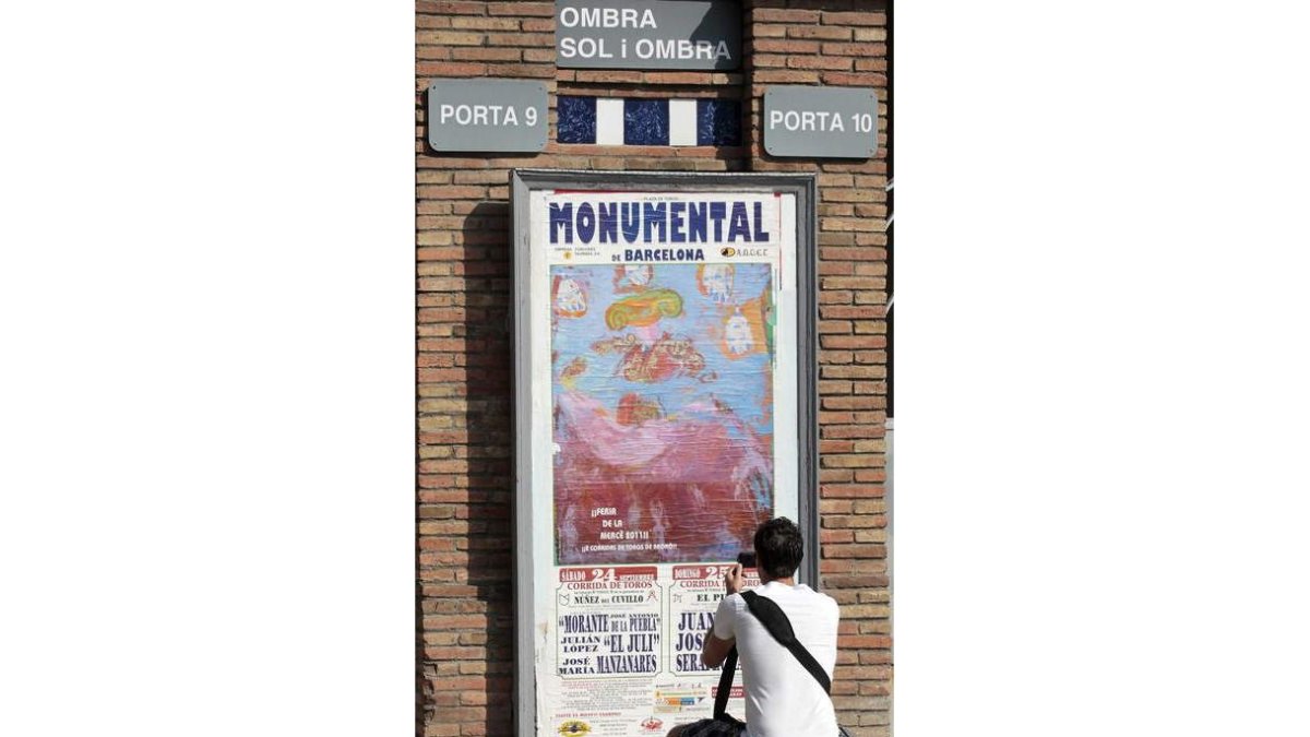 Un aficionado fotografía el cartel de la corrida.