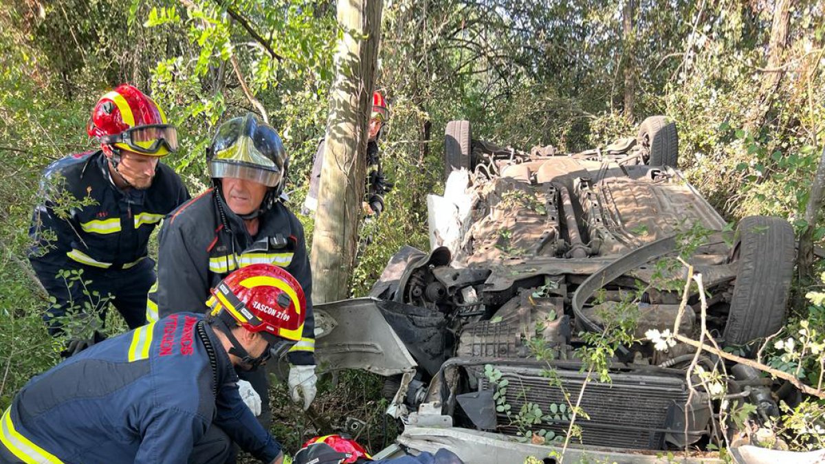 Bomberos de León en el momento del rescate de un conductor atrapado en el interior de su vehículo. BOMBEROS DE LEÓN