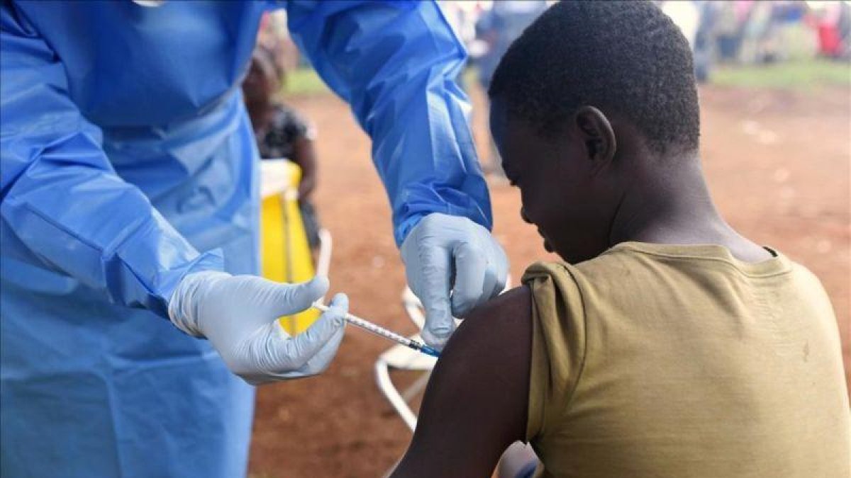 Un joven es vacunado contra el ébola por un médico congoleño.
