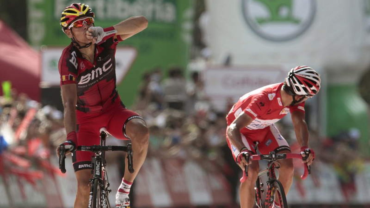 El ciclista belga Philippe Gilbert, izquierda, seguido del líder Joaquín ‘Purito’ Rodríguez, levanta el brazo tras ganar la etapa.