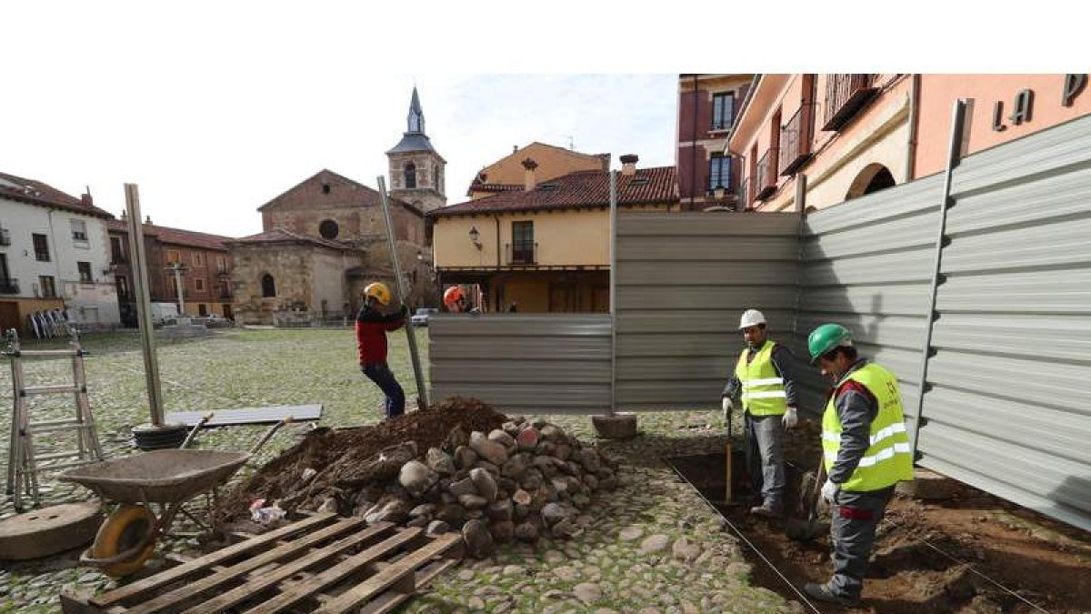 Los trabajadores de la empresa adjudicataria colocan ayer una valla tras los primeros trabajos para las catas. RAMIRO