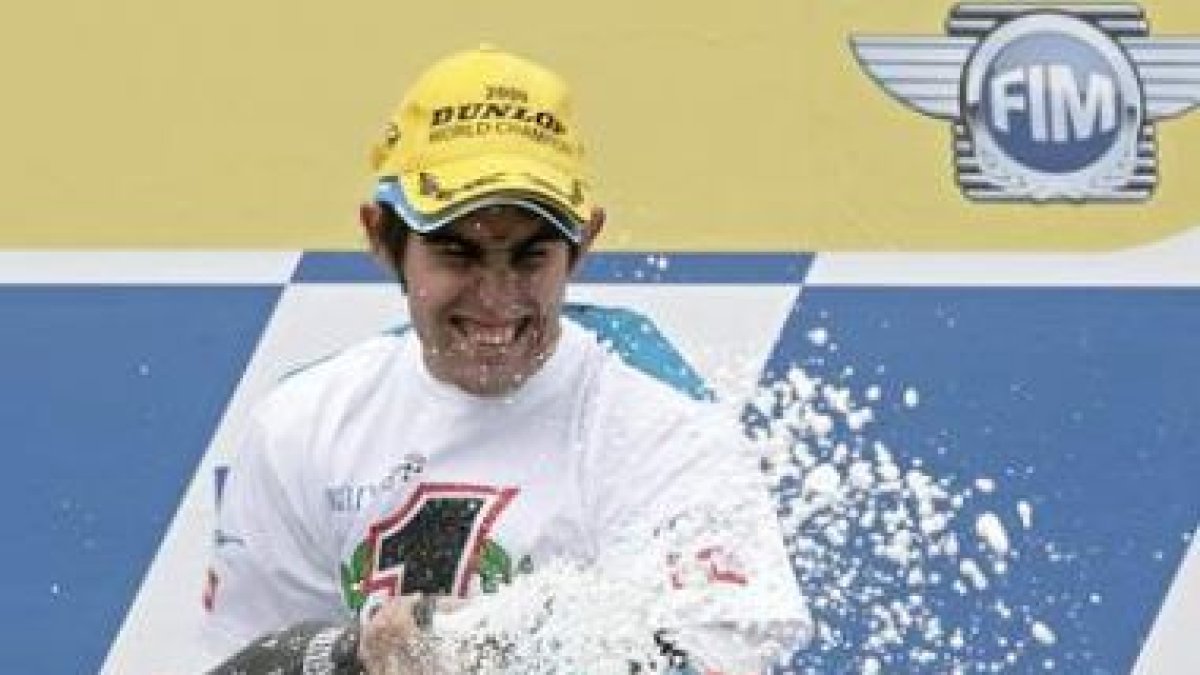 Simón, exultante en el podio, destapa el champán por su título mundial.