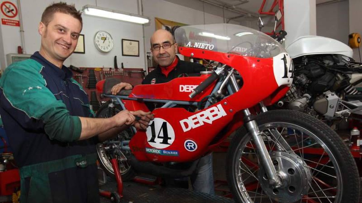 José María Suárez, a la izquierda, y Alberto Pertejo, retocando la réplica de la Derbi de 50 cc con la que Ángel Nieto conquistó tres títulos mundiales de motociclismo.