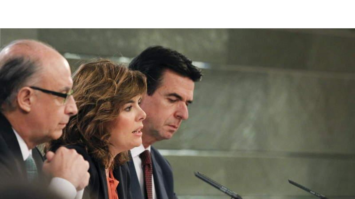 El ministro de Hacienda, Cristóbal Montoro, la vicepresidenta Soraya Sáenz de Santamaría y el titular de Industria, José Manuel Soria.