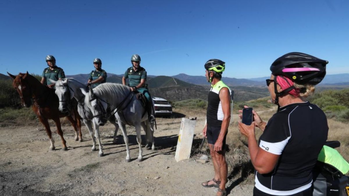 Dos peregrinos fotografían a los guardias civiles a caballo que velan por su seguridad en el Camino de Santiago.