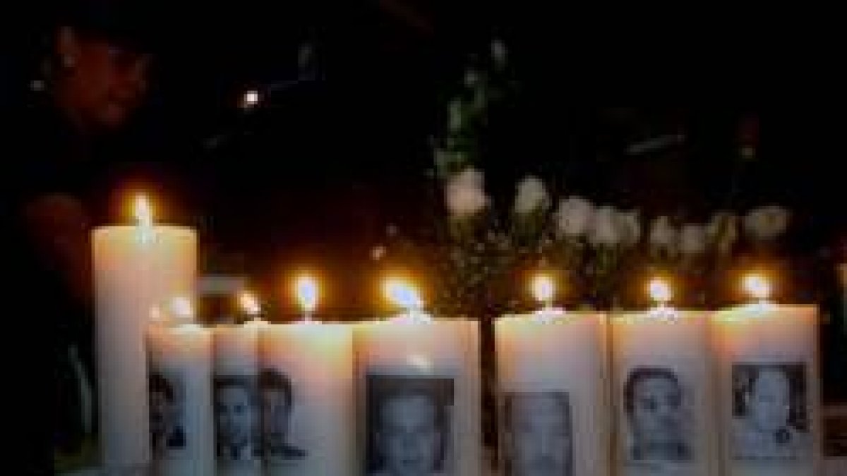 Velas con los rostros de los diputados fallecidos en una ceremonia