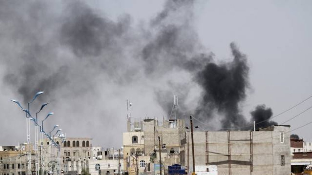 Una columna de humo se eleva del lugar donde se ha producido un bombardeo en la capital de Yemen.