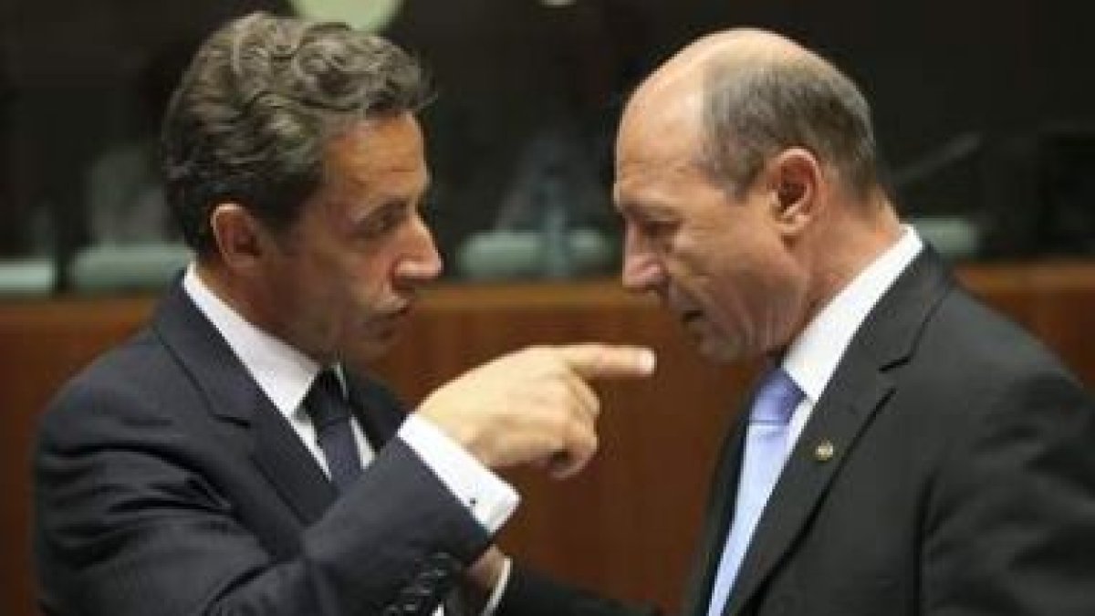 El presidente francés, Nicolas Sarkozy, conversa con su homólogo rumano, Traian Basescu, antes de co