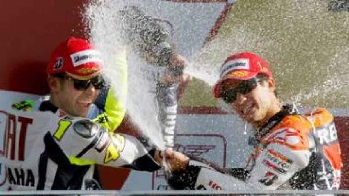 El piloto español de Moto GP Daniel Pedrosa (d) celebra en el podio su triunfo junto a Valentino Ros