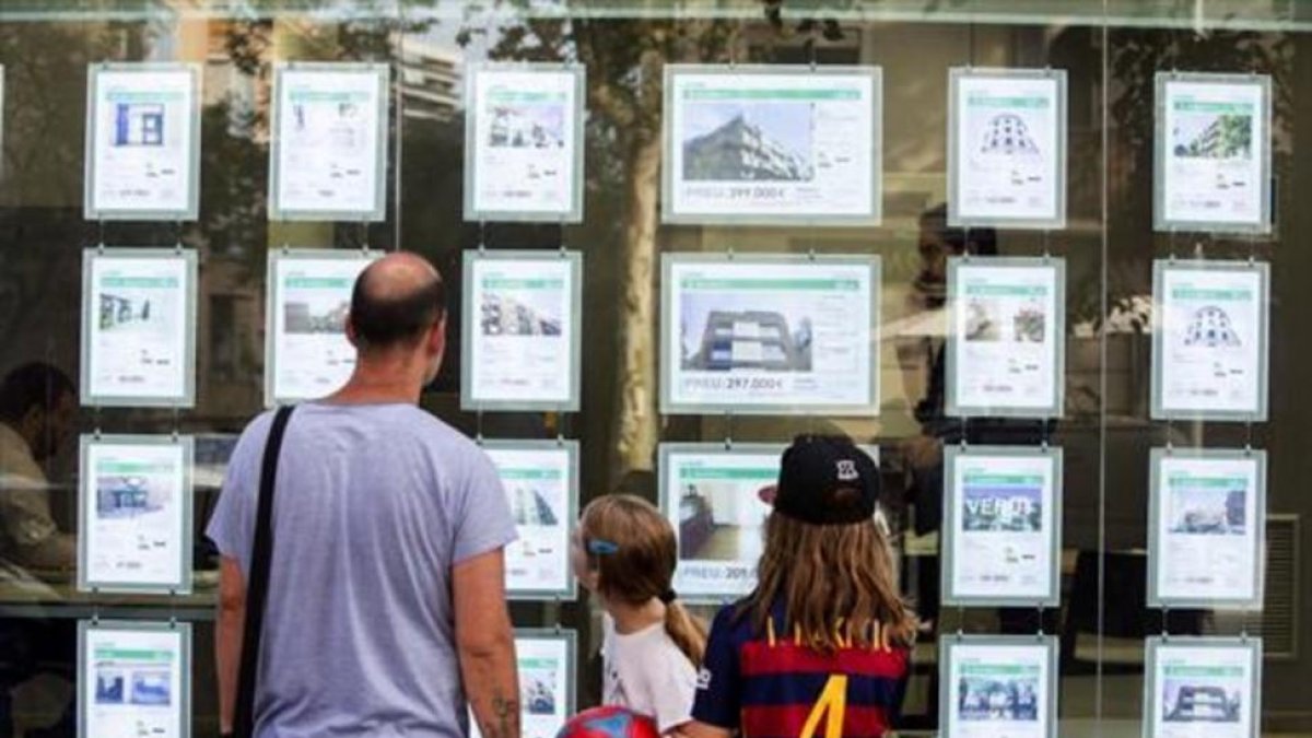 Una familia delante de una oficina inmobiliaria.