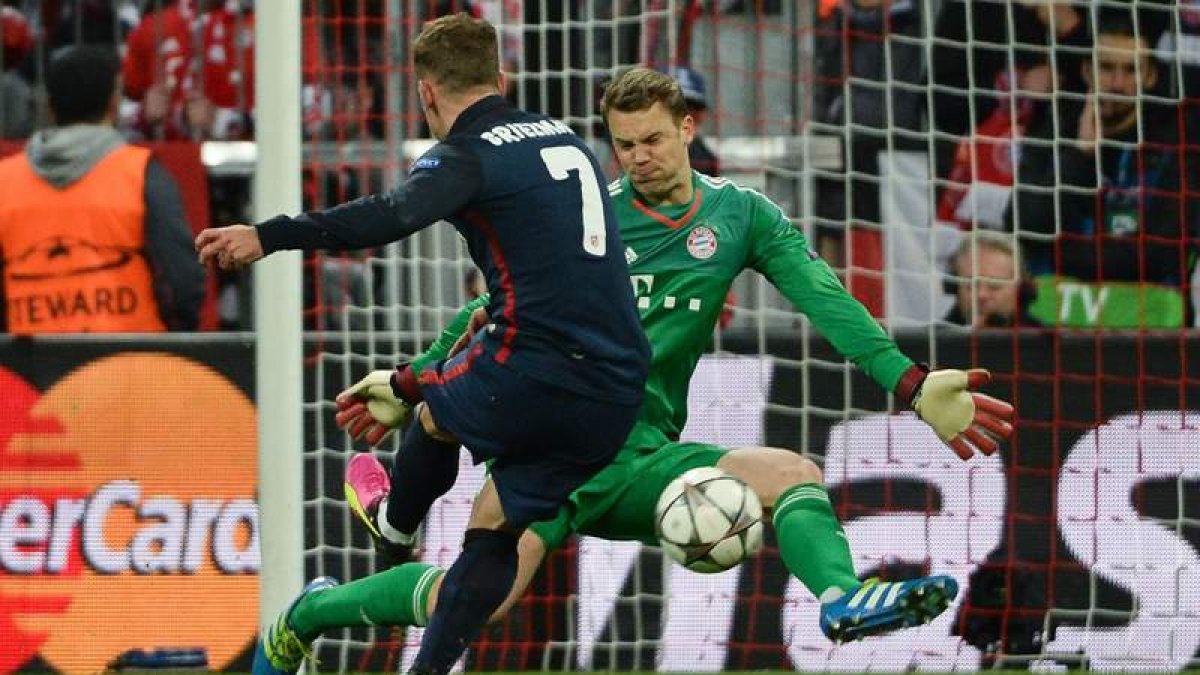 El jugador del Atlético Antoine Griezmann anota el gol del empate 1-1 ante el portero del Bayern Manuel Neuer. ANGELIKA WARMUTH