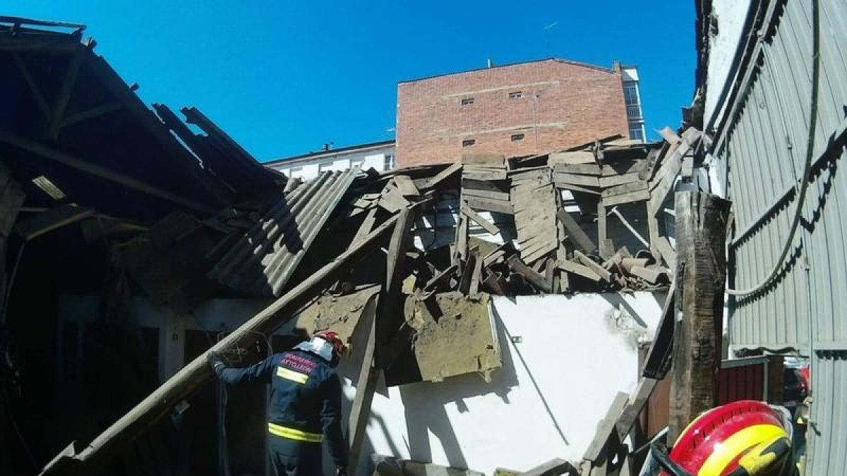 Los bomberos, en el interior de la nave derruida.