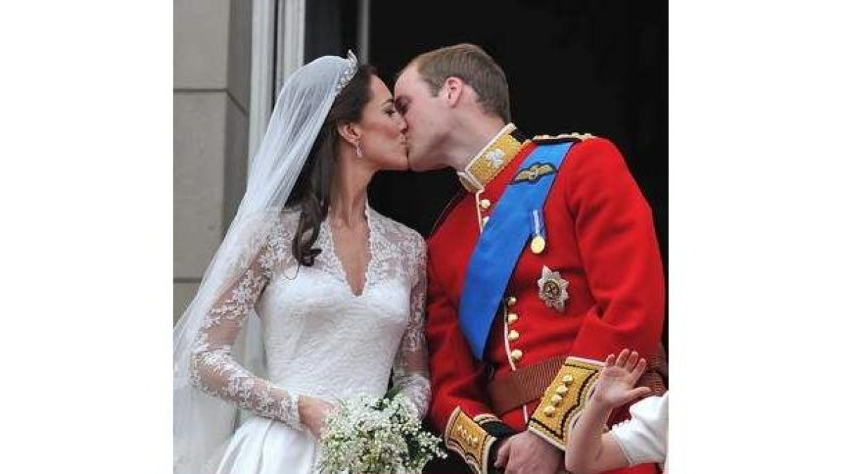 El príncipe Guillermo y su esposa Catalina, duques de Cambridge, se besan en el balcón del palacio d