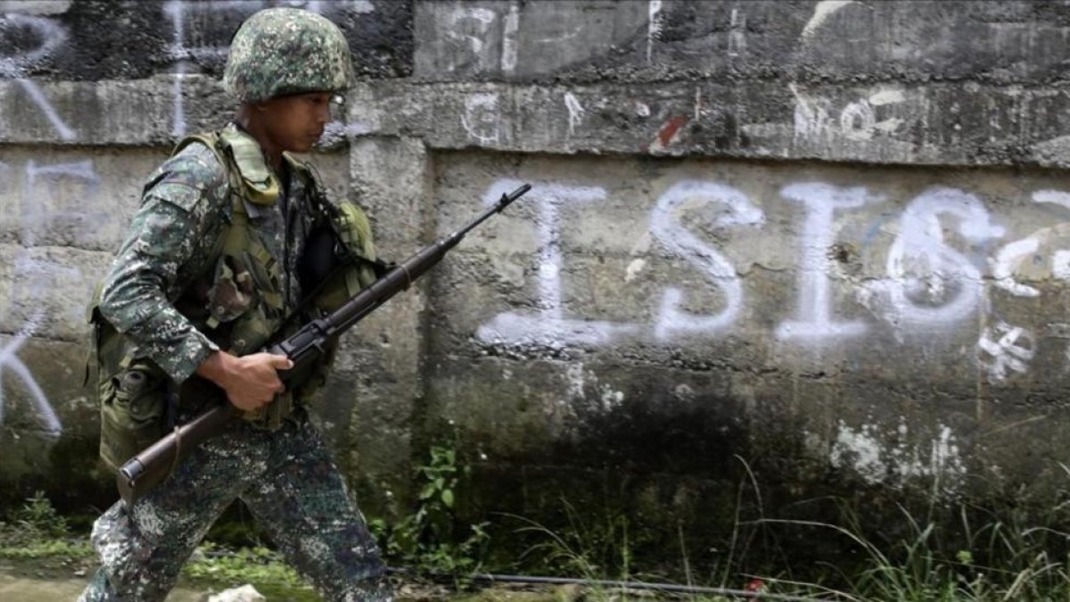 Un soldado filipino patrulla por un vecindario despues de un bombardeo durante los combates contra el EI.