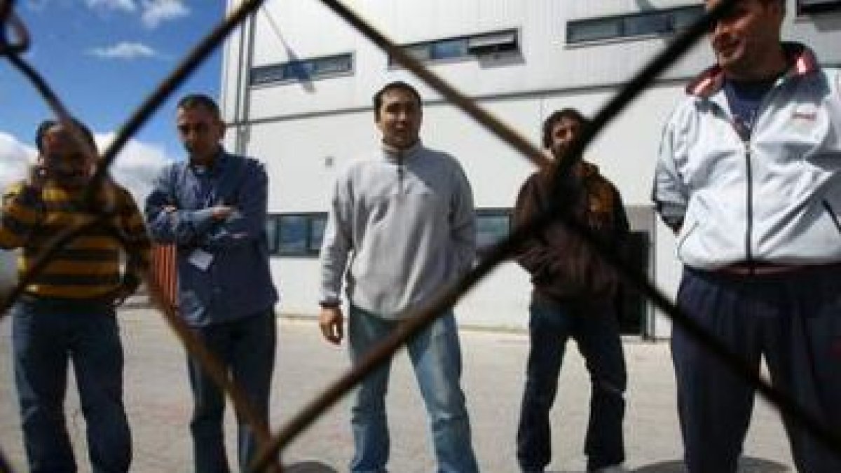 Los miembros del comité que protagonizan el encierro, ayer tras la valla de la factoría de LM en La