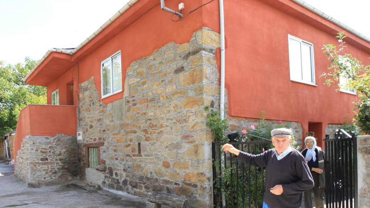 Aquilino Barreiro y su esposa junto a su casa restaurada.