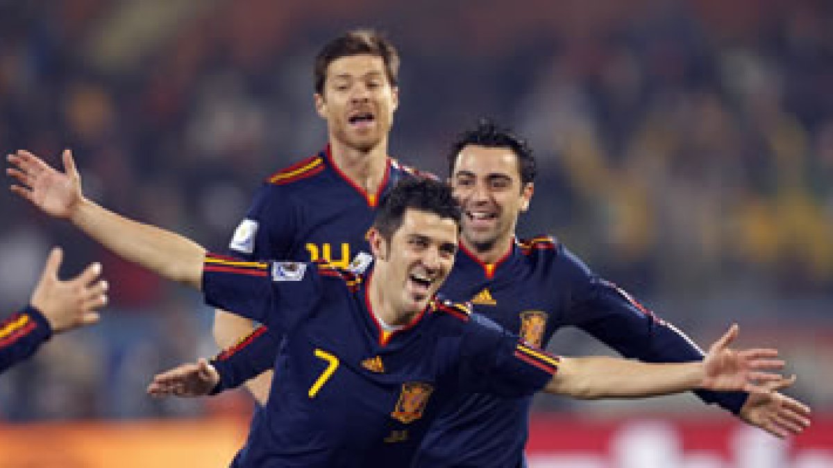 David Villa celebra el gol que abrió el triunfo de España momentos antes de recibir los abrazos de t