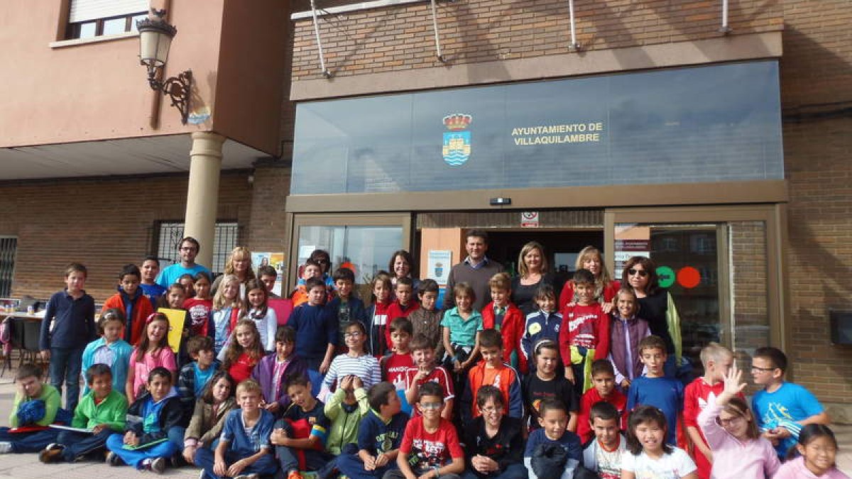 El alcalde, junto a varias concejalas y los niños del CRA de Navatejera, delante del Ayuntamiento.