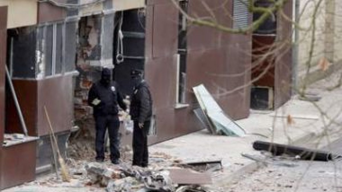 Agentes de la Ertzaintza durante la evaluación de los daños en la sede del Partido Socialista de Eus