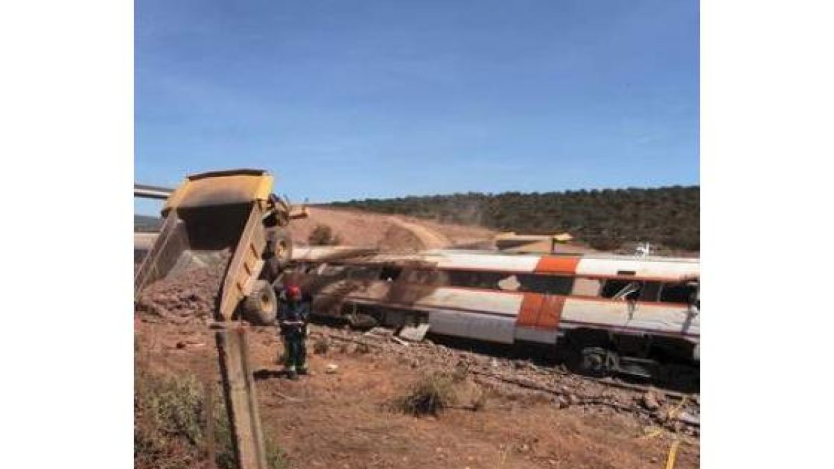 Varios bomberos junto al tren después del accidente.