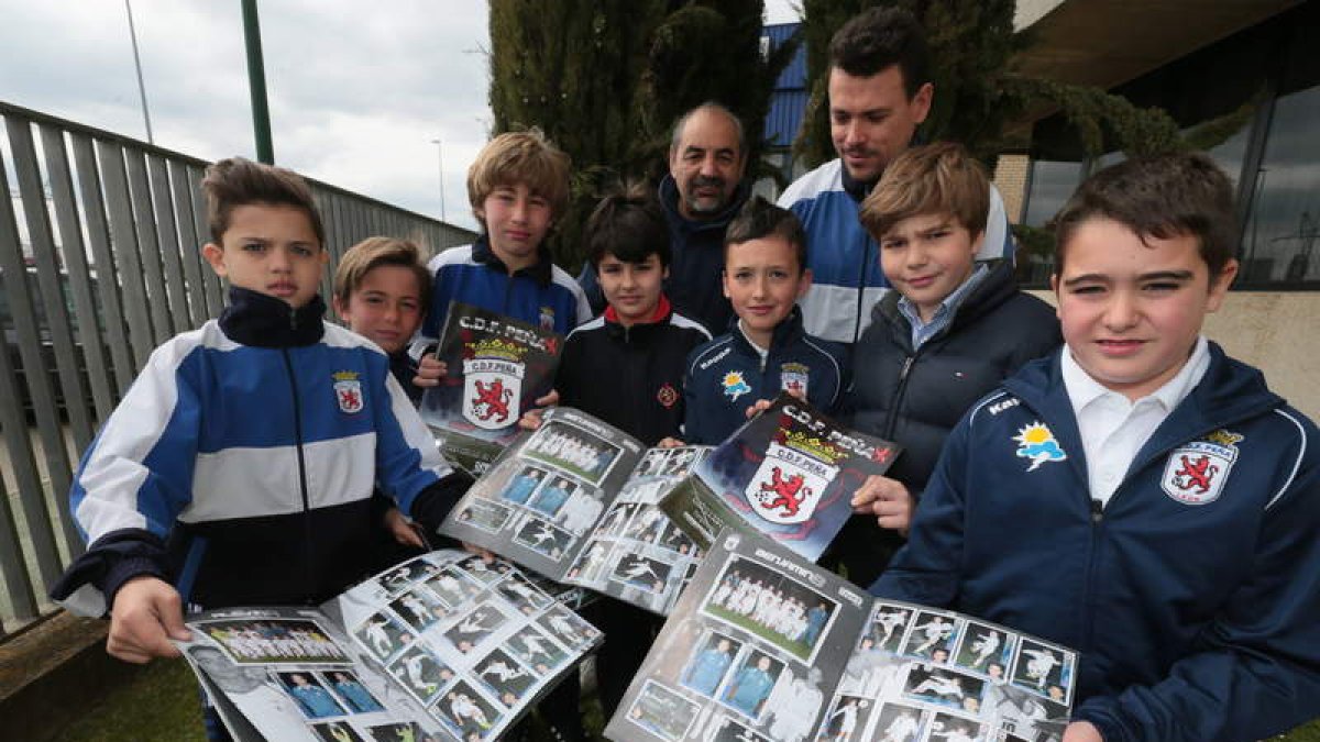 Los integrantes del equipo de la Peña con su presidente, Manuel Díaz, y el director deportivo, Rodrigo Blanco, posan con los álbumes de cromos del club leonés.
