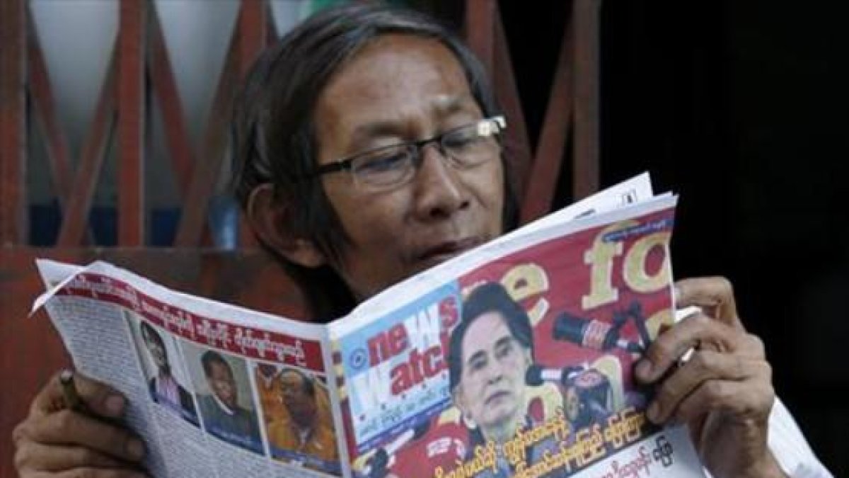 Un birmano lee un periódico donde Suu Kyi aparece en portada, este sábado.