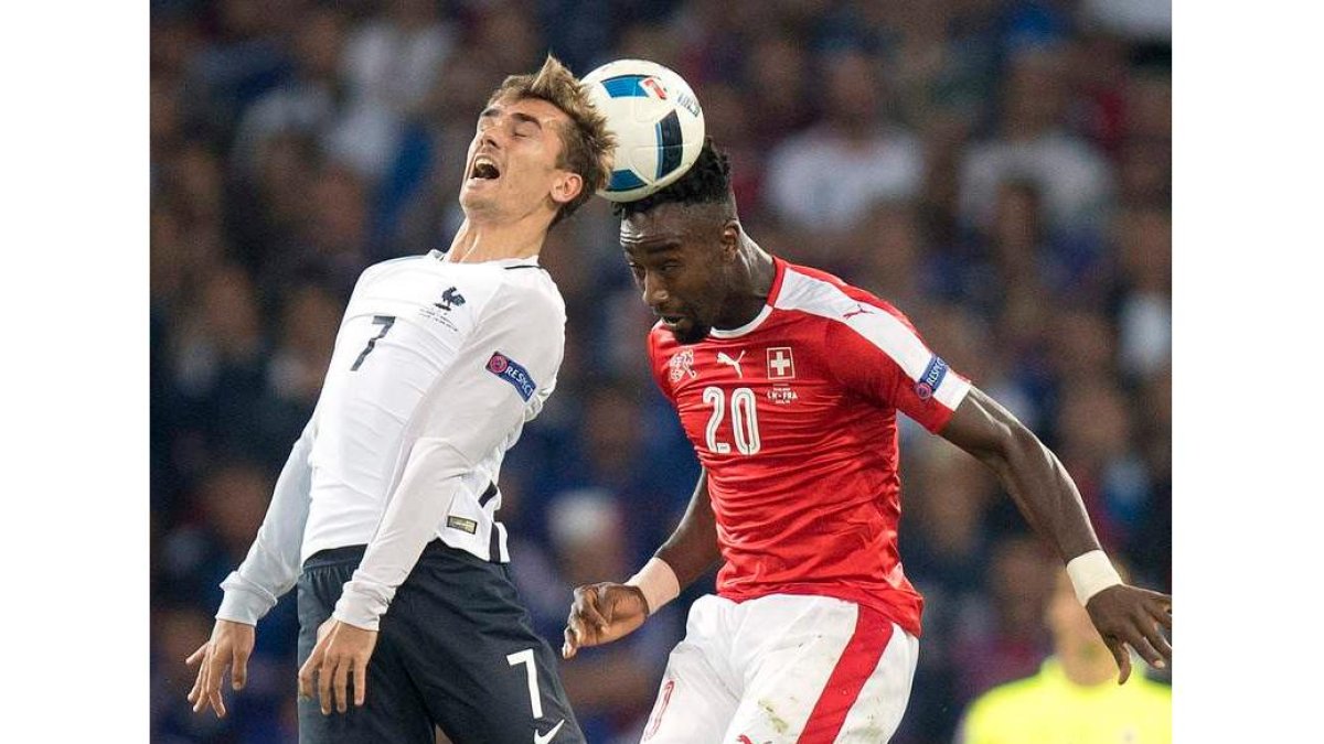 Griezmann y Djourou luchan por el balón durante el partido entre Suiza y Francia. JEAN-CHRISTOPHE BOTT
