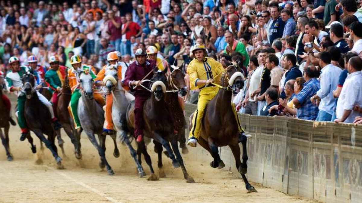 Varios competidores se disputan el Palio durante la carrera.